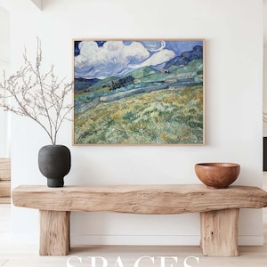 Puede incluir: Una pintura enmarcada de un paisaje con colinas onduladas, un cielo azul con nubes blancas y hierba verde. La pintura est&aacute; colgada en una pared blanca sobre un banco de madera. El banco est&aacute; hecho de madera toscamente labrada y tiene un acabado natural. El banco est&aacute; sentado en un suelo de madera clara. La pintura es una maqueta para una impresi&oacute;n de arte.