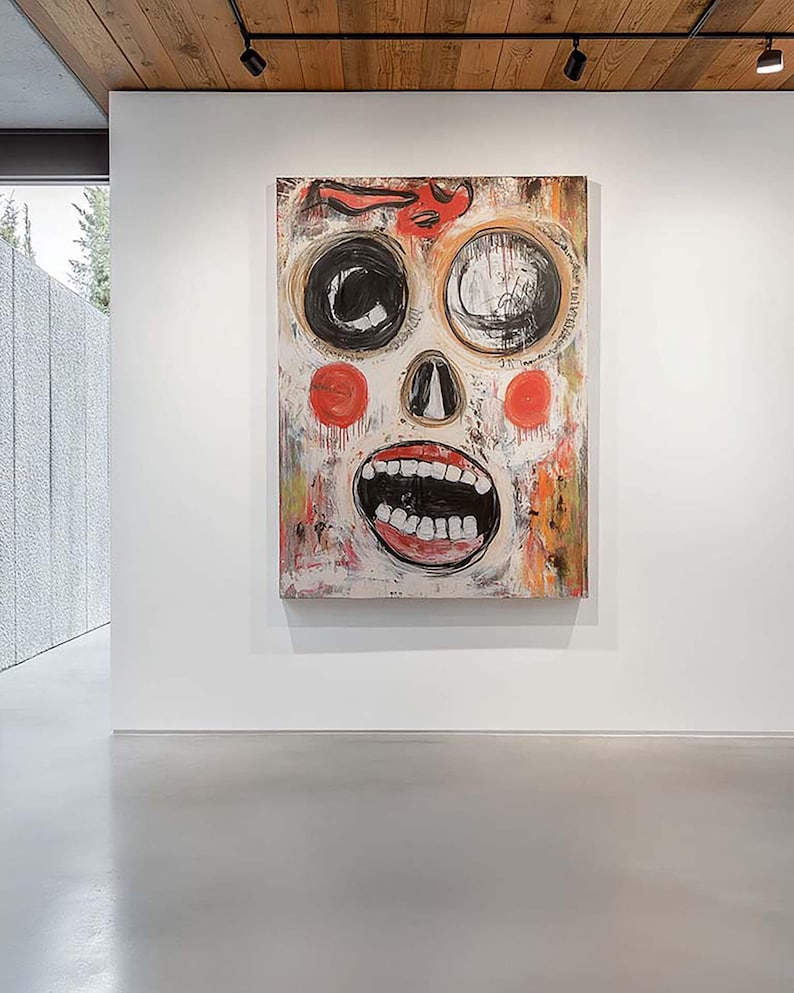 May include: Large abstract painting with a skull-like face. The artwork features large black and white eyes, red cheeks, and an open mouth with visible teeth. The background is a mix of colors, including red, orange, and white.