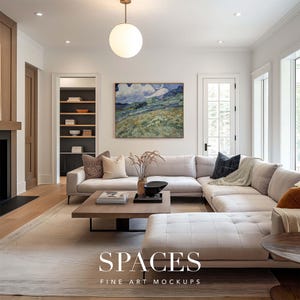 May include: A white sectional sofa with a throw blanket and pillows in a living room with a large painting of a landscape with clouds and a wooden coffee table with books on it.
