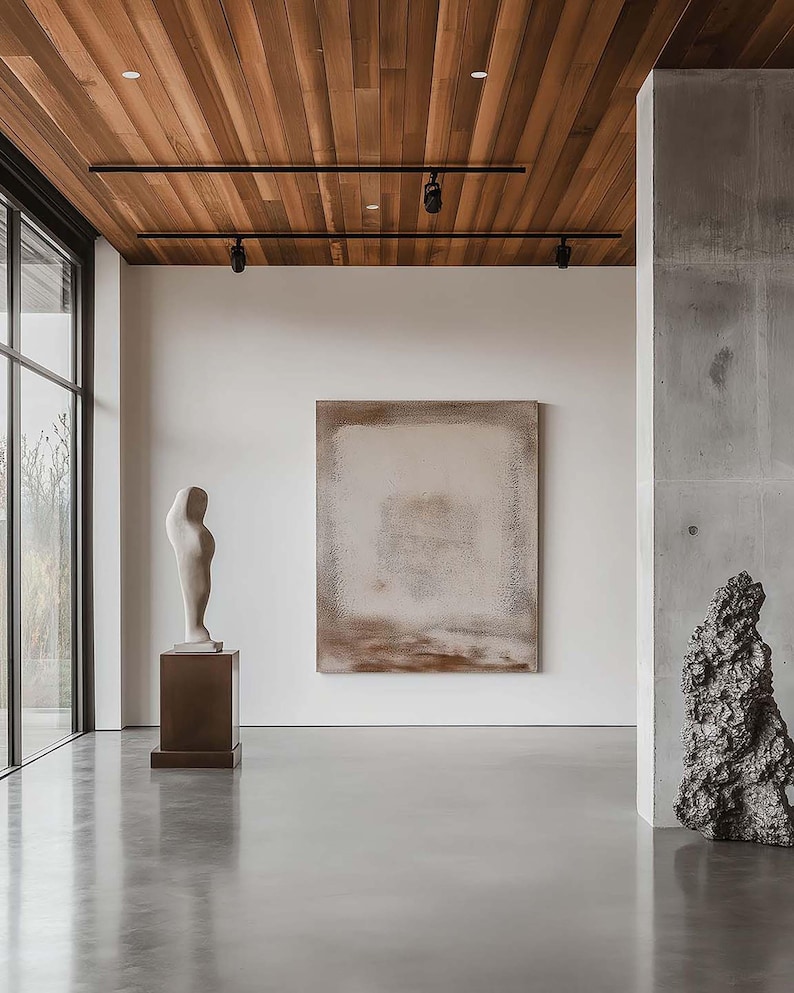 May include: An interior shot of a modern art gallery with a polished concrete floor and a wooden ceiling. The gallery features a large abstract painting, a white sculpture on a pedestal, and a dark, textured sculpture.