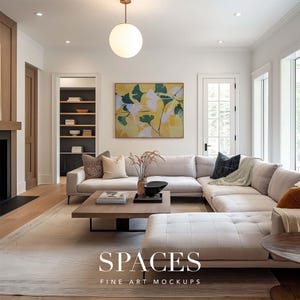 May include: A white sectional sofa with a light gray throw blanket and a dark gray pillow in a living room with a large abstract painting of yellow and green leaves on the wall. A wooden coffee table with books and a bowl sits in front of the sofa.