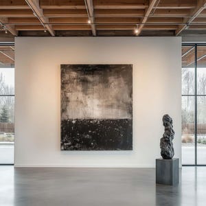 May include: An art gallery interior featuring a large abstract painting in shades of black and gray. A dark, textured sculpture stands on a gray pedestal. The room has a polished concrete floor and large windows.
