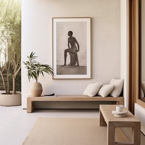 Peut inclure: Un espace de vie extérieur aux tons neutres, comprenant un banc en bois avec des coussins crème, une table basse rectangulaire et un tapis beige. Une œuvre d'art encadrée en noir et blanc est accrochée au-dessus du banc. Des plantes en pot complètent la scène.