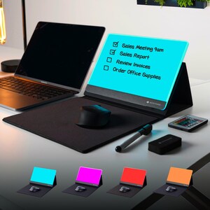 May include: A modern desk setup featuring a laptop, mouse, and a digital notepad displaying a to-do list: Sales Meeting 9am, Sales Report, Review Invoices, and Order Office Supplies. Additional colored notepads are displayed below.