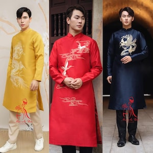 Pode incluir: Três trajes tradicionais vietnamitas áo dài. O primeiro é amarelo dourado com bordado de dragão branco. O segundo é vermelho com bordado de guindaste branco. O terceiro é azul marinho com bordado de fénix dourado. Cada roupa tem um logotipo correspondente.
