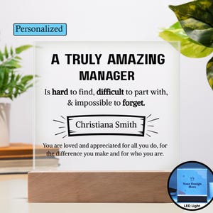 Può includere: Una luce a LED personalizzata con base in legno. Il pannello in acrilico trasparente mostra il testo "A Truly Amazing Manager" con un nome personalizzato. La luce include anche il testo "Is hard to find, difficult to part with, & impossible to forget."