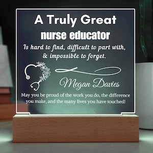 May include: A lighted acrylic plaque with the text "A Truly Great nurse educator." The plaque includes a stethoscope and floral heart design, the name "Megan Davies," and a motivational message. It sits on a wooden base.