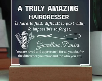 May include: A lit acrylic sign with the text "A Truly Amazing Hairdresser." The sign includes a barber pole and scissors graphic, and the name "Gwenllian Davies." The base is made of wood.
