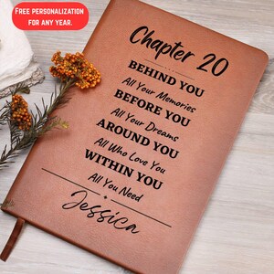 May include: A brown leather journal with the text "Chapter 20" and inspirational phrases. The journal is personalized with the name "Jessica" and includes a ribbon bookmark. The top left corner has a red box with the text "FREE PERSONALIZATION FOR ANY YEAR."