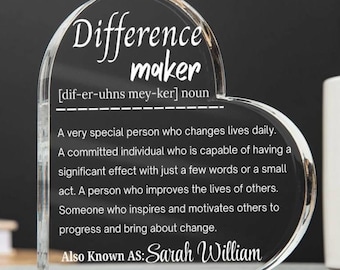Pode incluir: Placa de acrílico transparente em forma de coração com as palavras "Difference maker" em escrita elegante. A placa inclui uma definição e o nome "Sarah William". Um presente atencioso.