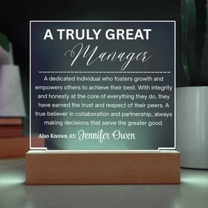 May include: An illuminated acrylic plaque with the words "A Truly Great Manager" and a description of a great manager. The plaque sits on a wooden base and includes the name "Jennifer Owen".