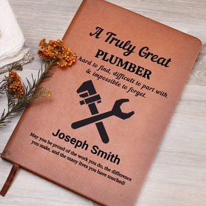 May include: A brown leather journal with the text "A Truly Great PLUMBER" and a wrench and pipe wrench graphic. The journal is personalized with the name "Joseph Smith" and a motivational quote.