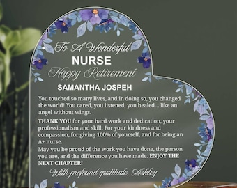 May include: Heart-shaped acrylic plaque with floral detailing and text. The plaque reads "To A Wonderful Nurse, Happy Retirement" and includes a personalized message and name. A retirement gift.