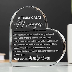 May include: A clear, heart-shaped acrylic plaque with the words "A Truly Great Manager" in white. The plaque includes a dedication and the name "Jennifer Owen". It is a gift for a manager.