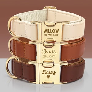 May include: Three dog collars stacked on top of each other. The top collar is cream coloured with gold hardware and the name "Willow" and address "123 Park Lane" engraved on the buckle. The middle collar is brown with gold hardware and the name "Charlie" and phone number "214-555-7647" engraved on the buckle. The bottom collar is dark brown with gold hardware and the name "Daisy" and a heart engraved on the buckle.