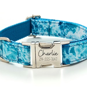 Puede incluir: Collar para perro azul y blanco con estampado y hebilla plateada. La hebilla está grabada con el nombre "Charlie" y el número de teléfono "214-555-7647".