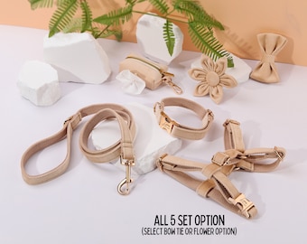 Könnte beinhalten: Ein Set aus fünf beigen Hunde-Accessoires, bestehend aus einer Leine, einem Halsband, einem Geschirr, einem Kotbeutelhalter und einer Auswahl zwischen einer Blume oder einer Schleife. Das Set ist auf einer weißen Oberfläche mit hellbraunem Hintergrund ausgelegt.  ALL 5 SET OPTION (SELECT BOW TIE OR FLOWER OPTION)