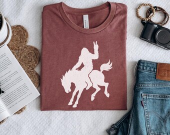 Sasquatch Cowboy Bucking Bronco Shirt, Bigfoot Peace Sign Rodeo Graphic Tee, Funny Western Cryptid Shirt, Rodeo Gift for Him