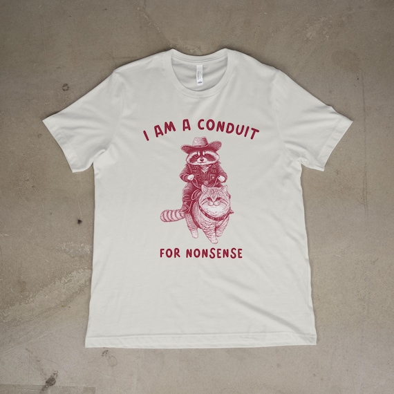 Funny Raccoon Cowboy Riding Cat T-Shirt, I Am a Conduit for Nonsense Shirt, Quirky Graphic Tee, Retro Animal Humor Shirt, Cowboy Cat Tee