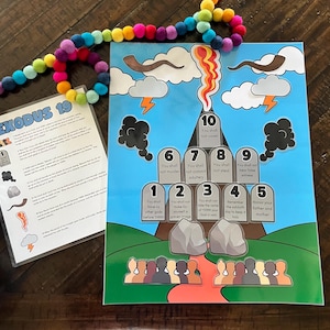 May include: A colorful educational poster with the Ten Commandments from Exodus 19. The poster features a mountain with a red path leading up to the top. There are ten stone tablets with the commandments written on them. The poster is illustrated with clouds, lightning bolts, and a ram's horn.