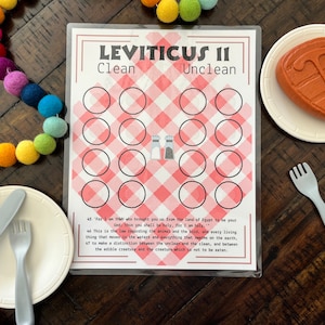 May include: A printable game card with a red and white checkered background. The card is titled "Leviticus II" and has two columns labeled "Clean" and "Unclean". There are 18 circles in each column, with salt shakers in the middle of the card.