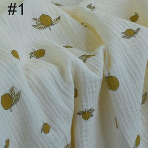 Op de afbeelding: Crèmekleurige stof met een herhalend patroon van gele citroenen en groene bladeren. De stof heeft een getextureerde, gekreukelde uitstraling. Het nummer "#1" staat in het zwart linksboven gedrukt. Geschikt voor naaiprojecten.