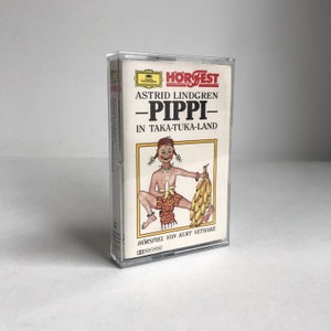 Può includere: Una cassetta audio con un'illustrazione colorata di Pippi Calzelunghe, un personaggio immaginario creato da Astrid Lindgren, sulla copertina. Il testo sulla cassetta audio recita "HÖR'FEST Astrid Lindgren -PIPPI- IN TAKA-TUKA-LAND HORSPIEL VON KURT VETHAKE".