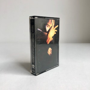 Könnte beinhalten: Ein schwarzes Kassettenband mit einem Totenkopf- und Knochenlogo. Das Band ist betitelt "Terence Trent D'Arby's Neither Fish Nor Flesh: A Soundtrack of Love, Faith, Hope and Destruction."