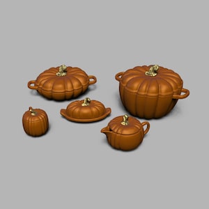 Może przedstawiać: Zestaw pięciu brązowych ceramicznych naczyń do serwowania w kształcie dyni, każde ze złotym trzonkiem. Zestaw zawiera mały słoik, maselniczkę, dzbanuszek do śmietanki oraz dwie miski z pokrywkami o różnych rozmiarach. Naczynia z motywem dyni są ułożone na szarym tle.
