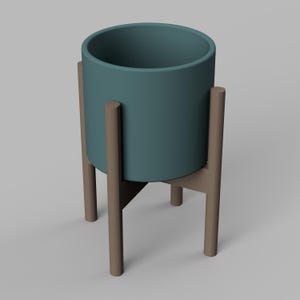 May include: A teal ceramic planter sits on a wooden stand with four legs. The stand is made of brown wood and has a simple design.