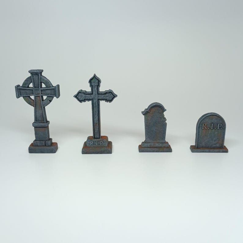 May include: Four miniature gray stone grave markers with a cross and the inscription "R.I.P."