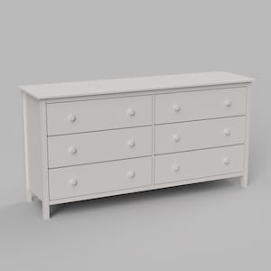 May include: A white six-drawer chest of drawers with round knobs. The drawers are arranged in two columns of three. The chest has a rectangular top and sits on four short legs.