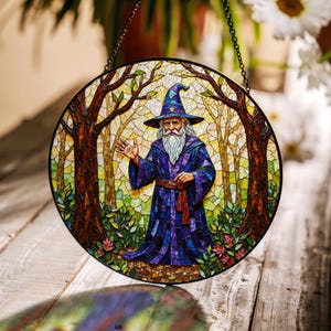 May include: A stained glass window hanging with a depiction of a wizard in a forest setting. The wizard is wearing a blue robe and a pointed hat. The background is a mosaic of green, brown, and yellow glass.