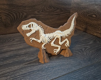 May include: A brown dinosaur skeleton fossil on a brown rock base. The skeleton is posed in a running position with its mouth open.