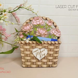以下が含まれることがあります： 花と「Happy Mother's Day」のハートが付いた木製のバスケットのレーザーカットファイル。ファイルはSVG、PDF、EPS、AI形式で入手できます。