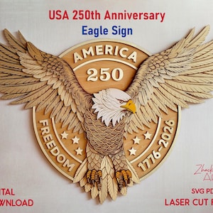 A wooden laser-cut eagle sign with the text "USA 250th Anniversary Eagle Sign". The eagle has outstretched wings and is centered on a circular emblem with the words "AMERICA 250" and "FREEDOM 1776-2026".