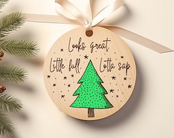 Puede incluir: Un adorno navideño redondo de madera con un árbol de Navidad verde y el texto "Looks great. Little full. Lotta sap."