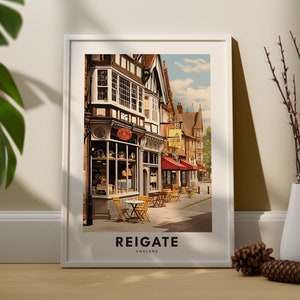 May include: A vintage-style illustration of a street scene in Reigate, England. The image features a brick building with a timber-framed facade, a shop with a red awning, and a cafe with tables and chairs outside. The text "Reigate, England" is printed below the image.