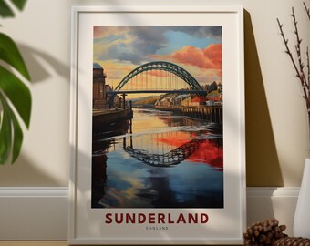 May include: A framed print of a painting depicting the Wearmouth Bridge in Sunderland, England. The bridge is a green steel arch bridge with a reflection in the water below. The sky is a vibrant orange and pink.