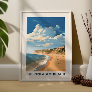 Könnte beinhalten: Ein weiß gerahmter Druck einer farbenfrohen Illustration einer Strandszene mit blauem Himmel, weißen Wolken, einem Sandstrand und einem blauen Meer. Der Text "SHERINGHAM BEACH NORTH NORFOLK" befindet sich am unteren Rand des Drucks.