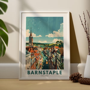 May include: A vintage-style travel poster featuring a colourful illustration of Barnstaple, England. The poster depicts a street scene with buildings, a church steeple, and a blue sky with white clouds. The text "Barnstaple, England" is printed in green at the bottom of the poster.