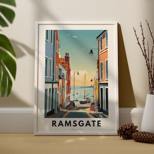 Puede incluir: Una ilustración colorida de una escena callejera en Ramsgate, Inglaterra. La calle está bordeada de edificios coloridos y conduce a una vista del mar con un velero en la distancia. El texto "RAMSGATE ENGLAND" está en la parte inferior de la imagen.