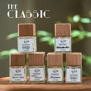 May include: Six small glass bottles with wooden caps and labels. The bottles contain car diffusers with different scents. The scents are: Shaken, Not Stirred, Irrefusable Offer, Queen's Gambit, Pride and Prejudice, Malèna, and Breakfast at Tiffany's. Each bottle contains 8 ml of diffuser.