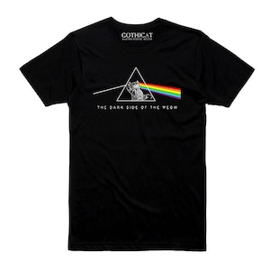 May include: Black t-shirt with a cat illustration inside a triangle, a rainbow beam, and the text "THE DARK SIDE OF THE MEOW". The shirt also has the text "GOTHICAT" at the top.