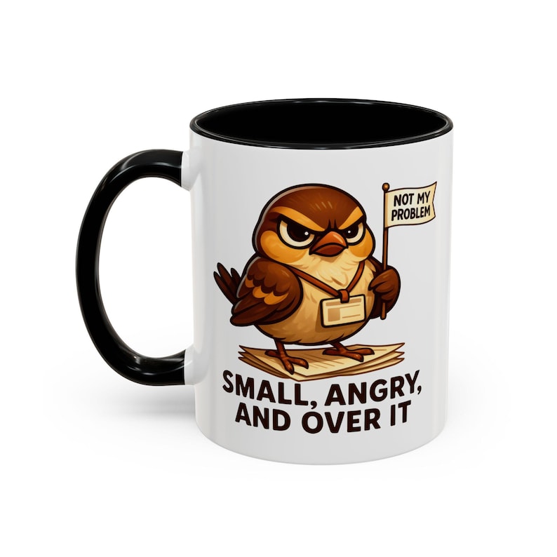 May include: White ceramic mug with a black handle and interior. The mug features a cartoon bird with an angry expression, holding a sign that reads "NOT MY PROBLEM." The text "SMALL, ANGRY, AND OVER IT" is below the bird.