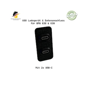 Könnte beinhalten: Schwarzes USB-Lade- und Datenanschlussgerät für BMW E28 & E30 Modelle. Es verfügt über zwei USB-C-Anschlüsse. Der Text auf dem Gerät lautet "USB Ladegerät & Datenanschluss für BMW E28 & E30" und "Mit 2x USB-C".