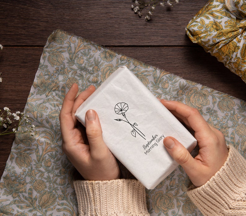 May include: A white gift box with a black and white illustration of a flower and the text "September Morning Glory".