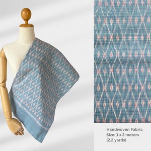 May include: Handwoven fabric in a blue and pink geometric pattern. The fabric is displayed on a mannequin and measures 1 x 2 meters (2.2 yards).
