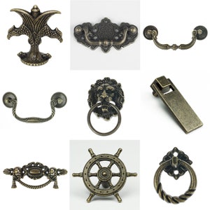 Könnte beinhalten: Sortiment an antiken Schrankbeschlägen in verschiedenen Designs, darunter ein Löwenkopf, ein Schiffsrad und ein Vogel mit ausgebreiteten Flügeln. Die Beschläge sind aus Metall und haben eine Bronze-Oberfläche.
