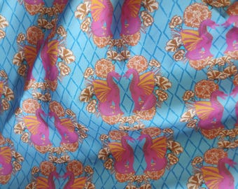 May include: A blue fabric with a repeating pattern of pink and orange dragons with floral accents. The dragons are facing each other and have wings.
